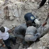 Tình nguyện viên Syria chuyển thi thể một nạn nhân sau một vụ không kích tại Aleppo ngày 4/10. (Nguồn: AFP/TTXVN)