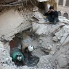 Tình nguyện viên Syria tìm kiếm người bị mắc kẹt trong những đống đổ nát sau một vụ không kích tại Aleppo ngày 4/10. (Nguồn: AFP/TTXVN)