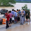 Hành khách được đưa lên canô ra nơi an toàn (ảnh chụp lúc 13 giờ ngày 15/10). (Ảnh: Đức Thọ/TTXVN)