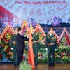 Chủ tịch nước Trần Đại Quang gắn Huân chương Quân công hạng Nhất lên lá cờ truyền thống của Quân khu 2. (Ảnh: Nhan Sáng/TTXVN)