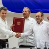 Tổng thống Colombia Juan Manuel Santos (trái, trước) và thủ lĩnh Lực lượng vũ trang Cách mạng Colombia (FARC) Timoleon Jimenez (phải, trước) tại lễ ký thỏa thuận hòa bình ở thủ đô La Habana, Cuba ngày 23/6. (Nguồn: THX/TTXVN)