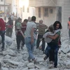 Chuyển người bị thương khỏi đống đổ nát của các tòa nhà sau cuộc không kích tại tỉnh Idlib ngày 29/9. (Nguồn: AFP/TTXVN)
