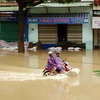 Đường Hùng Vương, thành phố Quy Nhơn bị ngập sâu, giao thông đi lại rất khó khăn. (Ảnh: Nguyên Linh/TTXVN)