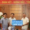 Đại sứ Nguyễn Mạnh Hùng đang tiếp nhận số tiền tượng trưng từ Đại diện câu lạc bộ Đồng hương Xi​eng Kho​ang. (Ảnh: Phạm Kiên/Vietnam+)