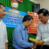 Ủy viên Bộ Chính trị, Bí thư Thành ủy Thành phố Hồ Chí Minh Đinh La Thăng tặng quà cho các gia đình chính sách khó khăn tại Khu phố 4, phường 7, quận 3. (Ảnh: Thế Anh/TTXVN)