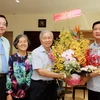 Bí thư Thành ủy Đinh La Thăng tặng hoa chúc mừng Nhà giáo nhân dân Phạm Chánh Trực. (Ảnh: Phương Vy/TTXVN)