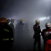 Lính cứu hỏa làm nhiệm vụ tại hiện trường vụ nổ trên phố Tharyar rạng sáng 21/11. (Nguồn: EPA/TTXVN)