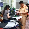 Công an quận Hai Bà Trưng, Hà Nội làm thủ tục đăng ký đăng ký xe môtô điện, xe máy điện cho nhân dân trước ngày 1/7/2016. (Ảnh: Doãn Tấn/TTXVN)