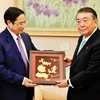 Đồng chí Phạm Minh Chính tặng quà lưu niệm cho Chủ tịch Hạ viện Nhật Bản Oshima Tadamori. (Ảnh: Gia Quân/TTXVN)