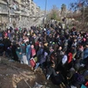 Những người dân Syria, từng phải sơ tán để tránh các cuộc giao tranh, tập trung tại điểm kiểm soát ở Maysaloun - khu vực lân cận với Aleppo ngày 8/12. (Nguồn: AFP/TTXVN)
