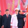 Thủ tướng Nguyễn Xuân Phúc gắn Huân chương Hồ Chí Minh lên Cờ truyền thống của Học viện Nông nghiệp Việt Nam. (Ảnh: Thống Nhất/TTXVN)