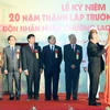 Thủ tướng Nguyễn Xuân Phúc gắn Huân chương Lao động hạng Nhất lên Cờ truyền thống của Trường Đại học Kinh doanh và Công nghệ Hà Nội. (Ảnh: Thống Nhất/TTXVN)