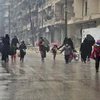 Người dân Syria sơ tán khỏi các khu vực do quân nổi dậy kiểm soát để đến các khu vực đã được quân Chính phủ giải phóng ở Aleppo ngày 13/12. (Nguồn: AFP/TTXVN)