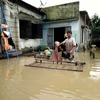 Người dân thôn Huỳnh Kim, phường Nhơn Hòa, thị xã An Nhơn, Bình Định làm vệ sinh nhà cửa khi nước vừa rút xuống. (Ảnh: Nguyên Linh/TTXVN)