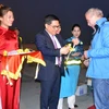 Ông Đỗ Đình Hồng, Giám đốc Sở Du lịch Hà Nội tặng hoa chào đón ông Thomas Bauche. (Ảnh: Kim Chung/TTXVN)