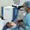 Bác sỹ Bệnh viện Mắt Thành phố Hồ Chí Minh thực hiện ca phẫu thuật khúc xạ mắt bằng Laser công nghệ SmartSurfACE cho bệnh nhân. (Ảnh: Phương Vy/TTXVN)