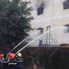 Lực lượng cứu hỏa phun nước dập tắt đám cháy trong nhà xưởng. (Ảnh: Thanh Liêm/TTXVN)