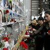 Đặt hoa và thắp nến trong lễ tưởng niệm các nạn nhân tại nơi xảy ra vụ khủng bố Beslan. (Nguồn: AFP/TTXVN)