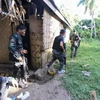 Cảnh sát và binh sỹ Philippines trong chiến dịch truy quét các phần tử Abu Sayyaf ở thị trấn Inabanga, tỉnh Bolo, miền trung Philippines ngày 11/4. (Nguồn: AFP/TTXVN)