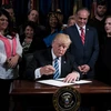 Tổng thống Mỹ Donald Trump (giữa) ký một sắc lệnh ở Washington, DC ngày 27/4. (Nguồn: AFP/TTXVN)