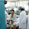 Bộ trưởng Bộ Y tế Nguyễn Thị Kim Tiến đến thăm, tặng quà động viên các bệnh nhân được chuyển về điều trị tại Bệnh viện Bạch Mai. (Ảnh: Dương Ngọc/TTXVN)