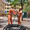 Công nhân điện lực Hà Nội kéo bổ sung nguồn dây cấp điện cho khu dân cư. (Ảnh Mạnh Khánh/TTXVN)