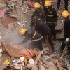 Nhân viên cứu hộ tìm kiếm nạn nhân bị vùi lấp dưới những đống đổ nát trong vụ sập nhà ở Mumbai. (Nguồn: EPA/TTXVN)