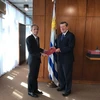 Đại sứ Việt Nam tại Argentina Đặng Xuân Dũng trao bản sao thư ủy nhiệm tới Ngoại trưởng Uruguay Rodofo Nin Novoa. (Ảnh do Đại sứ quán Việt Nam tại Argentina cung cấp)