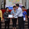 Chủ tịch MTTQ Việt Nam Trần Thanh Mẫn thăm hỏi, động viên và trao 55 triệu đồng cho 11 em học sinh thuộc các gia đình bị thiệt hại trong trận lũ quét tại huyện Mường La, tỉnh Sơn La. (Ảnh: Nguyễn Chiến/TTXVN)