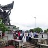 Người Mông lên tượng đài Chiến thắng trên đồi D1 để ngắm cảnh phố phường lòng chảo Mường Thanh. (Ảnh: Xuân Tiến/Vietnam+)