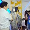 Chủ tịch HĐQT Đường Nhất Lâm tiến hành thí nghiệm về tính dẫn điện của bộ quần áo. (Ảnh: Vĩnh Hà/Vietnam+)