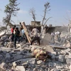 Tìm kiếm các nạn nhân dưói những đống đổ nát sau vụ không kích tại tỉnh Idlib ngày 20/9. (Nguồn: AFP/TTXVN)