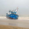 Tàu cá PY99777TS của ngư dân Phú Yên bị sóng đánh dạt vào bờ biển thành phố Quy Nhơn. (Ảnh: Phạm Kha/TTXVN)