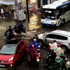 Các phương tiện giao thông di chuyển khó khăn do nước ngập tại khu vực ngã tư đường Calmette, Quận 1, Tp. Hồ Chí Minh. (Ảnh: TTXVN phát)