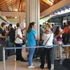 Hành khách đợi xe buýt tại sân bay Bali ngày 28/11. (Nguồn: Kyodo/TTXVN)