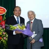 Thủ tướng Nguyễn Xuân Phúc tặng hoa chúc mừng giáo sư Hoàng Tuỵ. (Ảnh: Thống Nhất/TTXVN)