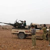 Các tay súng nổi dậy Syria giao tranh với quân đội Chính phủ Syria ở làng Arafa, tỉnh Hama ngày 20/11. (Nguồn: AFP/ TTXVN)