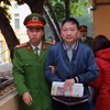 Cảnh sát dẫn giải bị cáo Trịnh Xuân Thanh vào phòng xét xử. (Ảnh: Doãn Tấn/TTXVN)