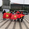 Các cổ động viên mang theo quốc kỳ để tiếp lửa cho U23 Việt Nam. (Nguồn: Vietnam+)