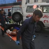Chuyển người bị thương khỏi hiện trường vụ đánh bom. (Nguồn: THX/ TTXVN)