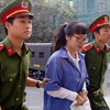 Dẫn giải bị cáo Huỳnh Thị Huyền Như đến phiên tòa 8/2. (Ảnh: Hoàng Hải/TTXVN)