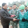 Đồng chí Phạm Minh Chính tặng quà công nhân ngành Than Quảng Ninh. (Ảnh: Văn Đức/TTXVN)