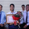 Vận động viên Nguyễn Ngọc Hiệp (giữa) nhận thưởng tại buổi biểu dương lực lượng thể thao Thành phố Hồ Chí Minh thi đấu xuất sắc tại ASEAN Paragame 9. (Ảnh: Xuân Dự/TTXVN)