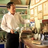 Thầy giáo Võ Thanh Phương với những cổ vật sưu tầm được. (Ảnh: Phước Ngọc/TTXVN)