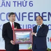 Thủ tướng Nguyễn Xuân Phúc tặng Chủ tịch Ngân hàng Phát triển châu Á (ADB) Takehiko Nakao bức ảnh do phóng viên TTXVN chụp các Trưởng đoàn tham dự Hội nghị Thượng đỉnh GMS 6. Ảnh: TTXVN
