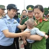 Lực lượng chức năng Việt Nam tiếp nhận em bé bị bán sang Trung Quốc. (Ảnh:Nguyễn Hoàng/TTXVN)