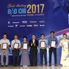 Đồng chí Nguyễn Đức Lợi, Ủy viên BCH Trung ương Đảng, Tổng Giám đốc Thông tấn xã Việt Nam trao giải A cho các tác giả đoạt giải. (Ảnh: Văn Điệp/TTXVN)