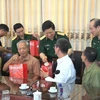 Đại tướng Ngô Xuân Lịch tặng quà các gia đình chính sách huyện Lý Nhân tại buổi tiếp xúc cử tri. (Ảnh: Thanh Tuấn/TTXVN)