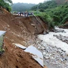 Đoạn đường bị đứt 30m do mưa lũ gây ra tại km 369, quốc lộ 32 huyện Tân Uyên đi Than Uyên khiến giao thông chia cắt. (Ảnh: Quý Trung/TTXVN)