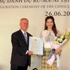 Ông Valeriu Arteni, Đại biện Romania tại Việt Nam (trái) trao Thư bổ nhiệm Lãnh sự Danh dự Romania tại Thành phố Hồ Chí Minh cho bà Trần Thị Thanh Nhàn (phải). (Ảnh: Xuân Khu/TTXVN)